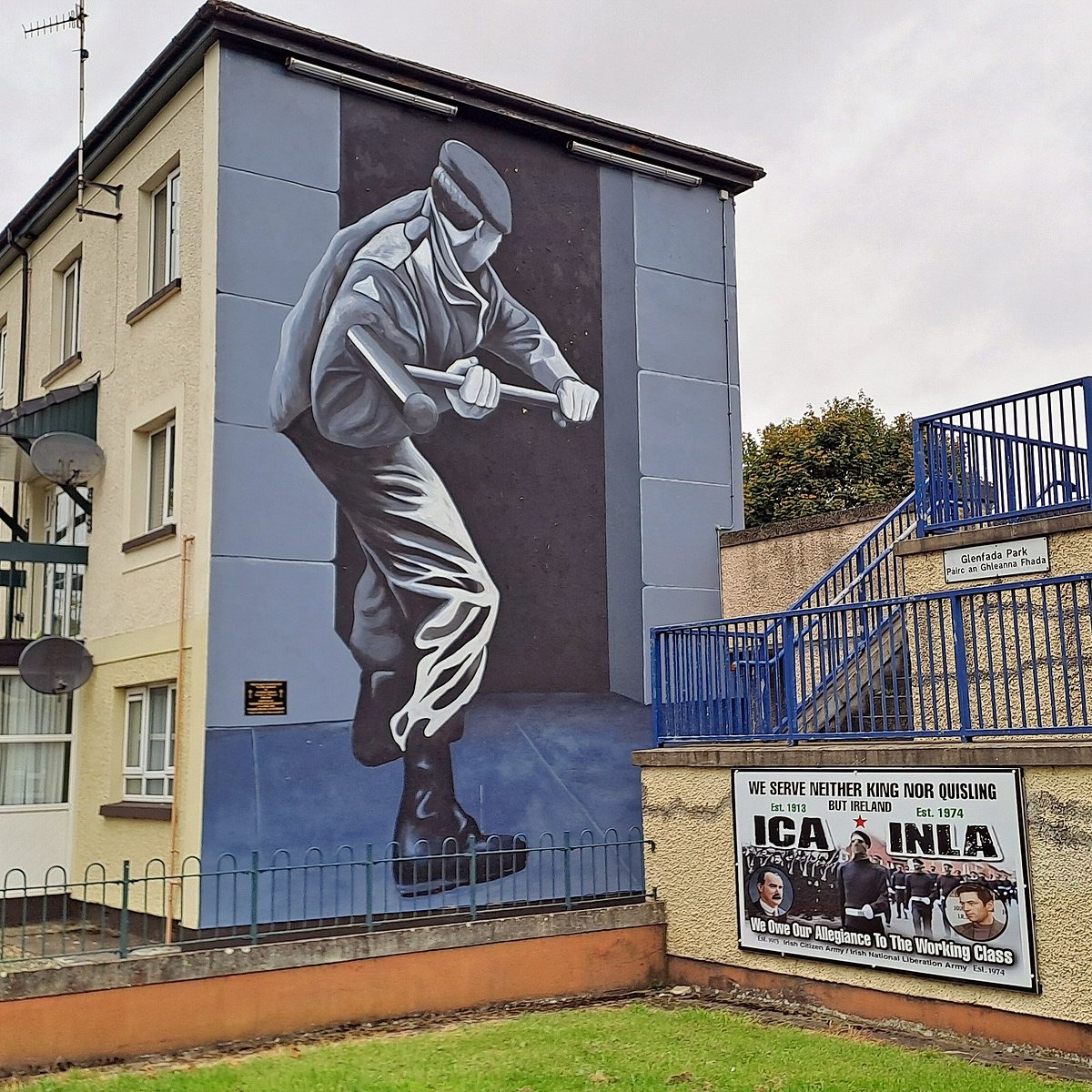 A Bogside mural of a masked figure swinging a sledgehammer, near Glenfada Park