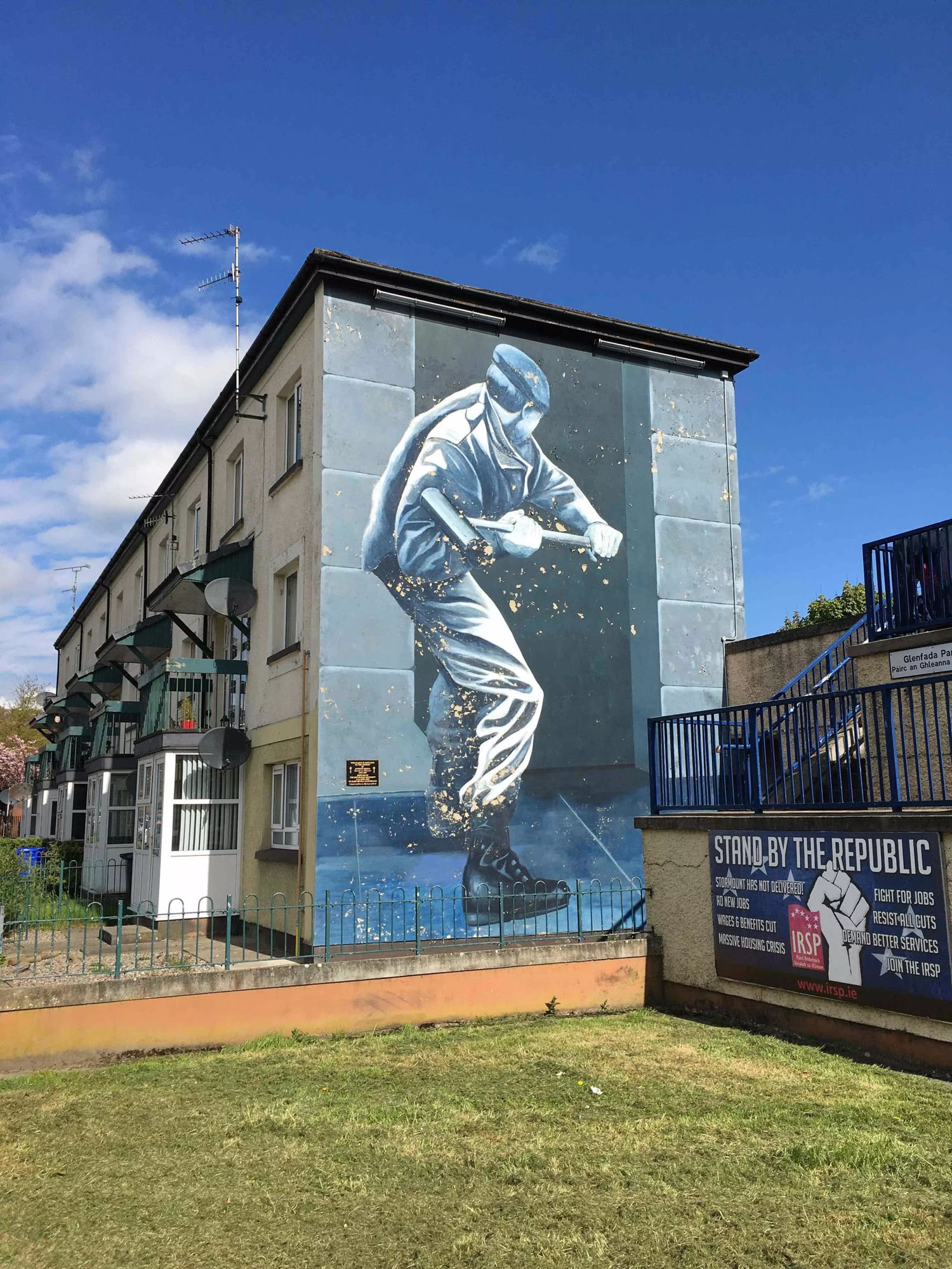 A Bogside mural of a masked figure with a sledgehammer, on a gable end at Glenfada Park