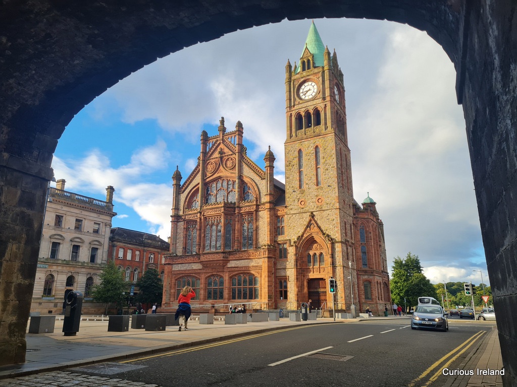 The Guildhall and its clock tower on Guildhall Square, framed by a stone arch